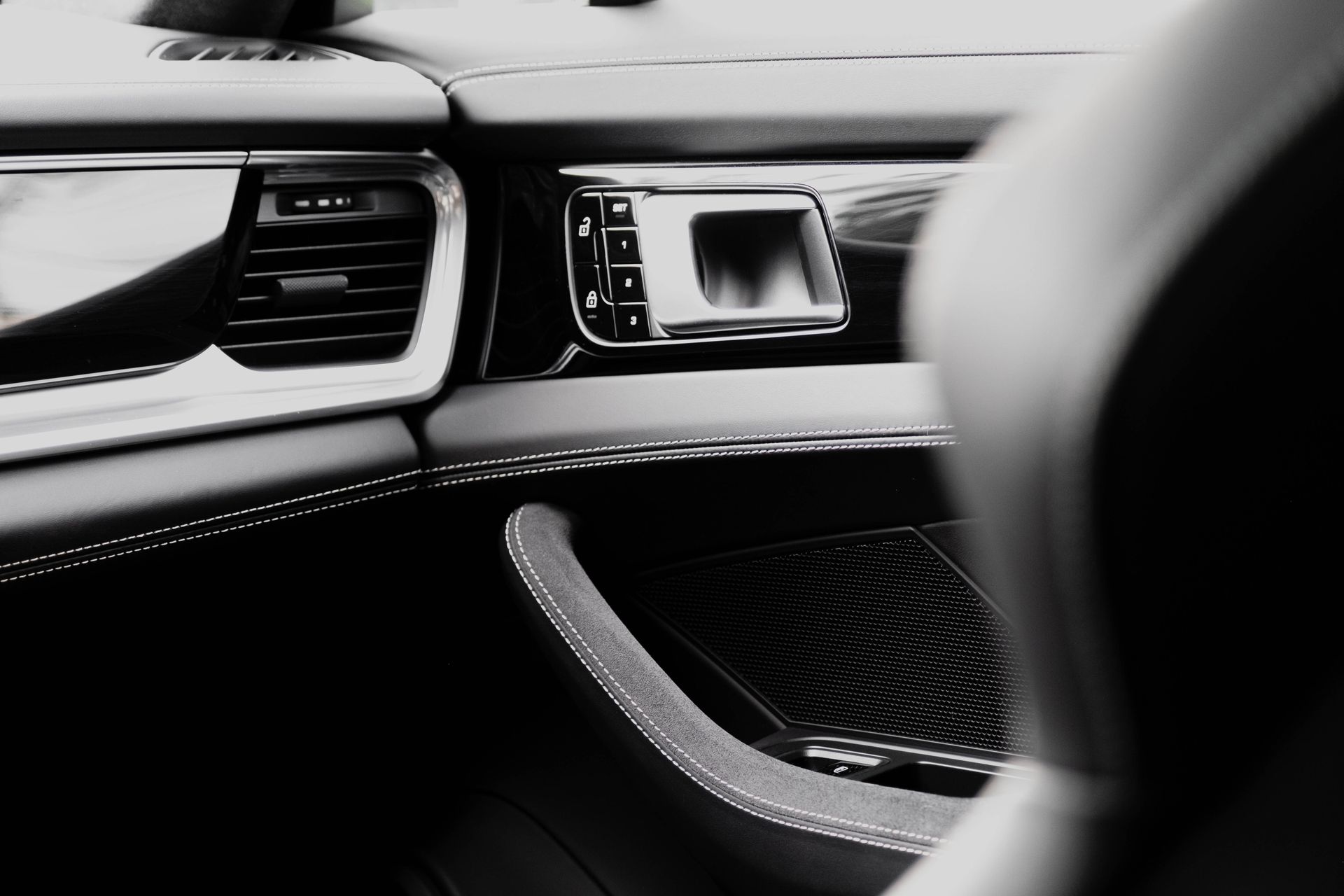 Spotless door panel and stitched trim inside a detailed luxury sedan