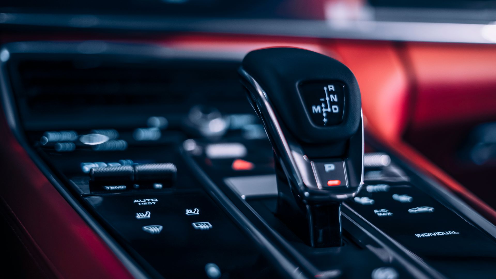 Detailed centre console and gear selector in a red-lit luxury interior